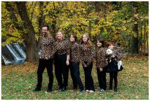 Family recreates an awkward family photo with everyone standing in a line and wearing matching leopard turtlenecks.