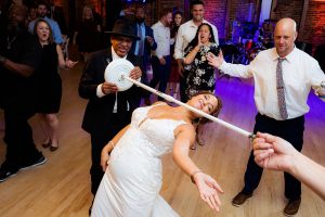 Bride limbos under a mic stand during her reception party at the American Visionary Art Museum.