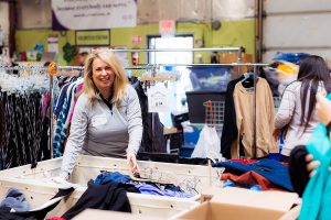 A volunteer sorts and sizes clothing at a corporate volunteer event in Sterling, Virginia.