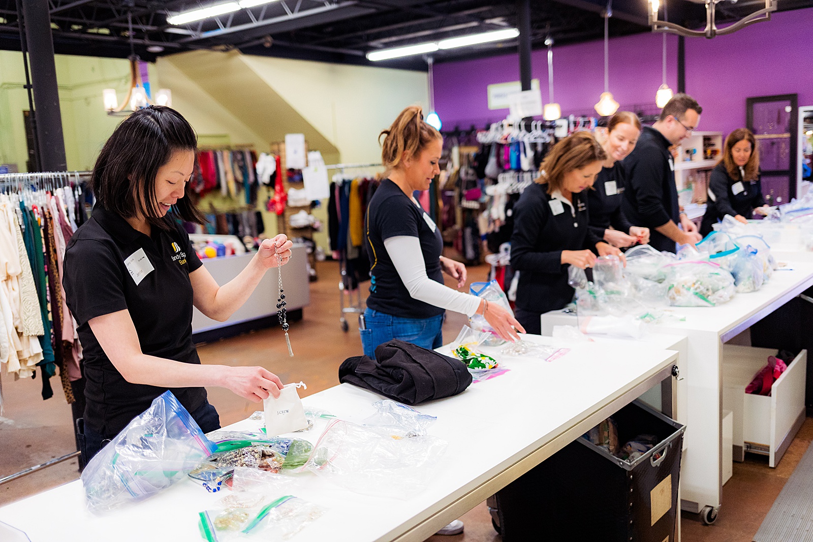 A group of volunteers sorts through jewelry to help assemble a prom boutique at Women Giving Back. 