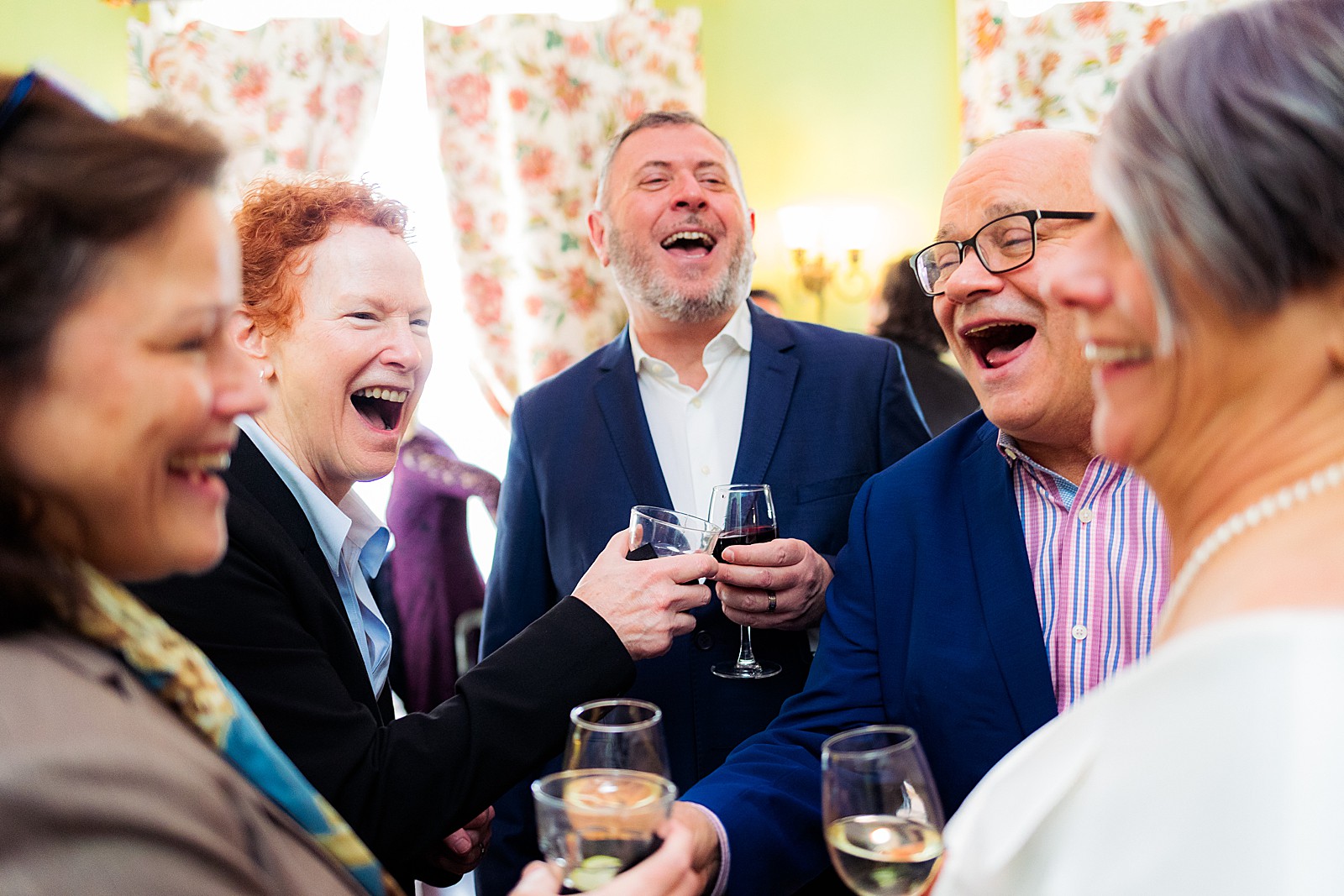 A group of friends makes a cheers and laughs during a cocktail hour at the Tabard Inn. 