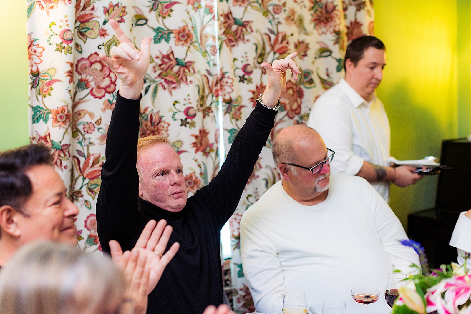 A man celebrates winning a trivia game at a wedding. 