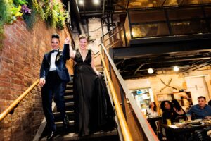LGBTQ+ couple walks down staircase after their elopement at Maydan restaurant in DC.
